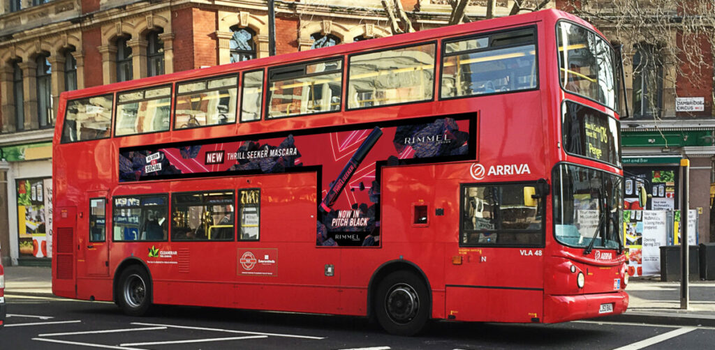 Rimmel is celebrating the unveiling of its new Thrill Seeker Pitch Black mascara with a two-fold campaign aimed at targeting its Gen Z consumers, depicted here on a red double decker bus with the beauty brand's promotional advertising alongside it.
