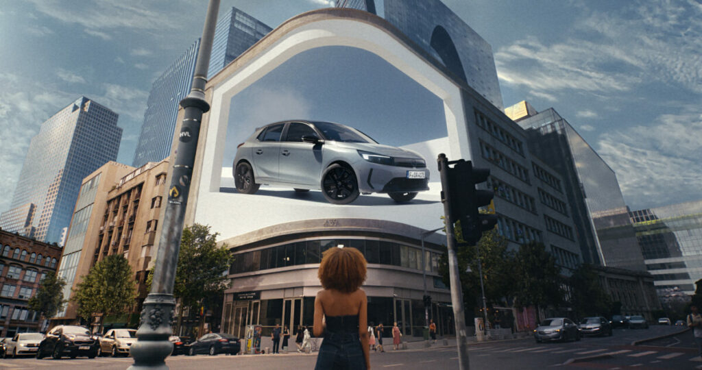 Opel is convincing hesitant buyers wanting to switch to a fully electric car that it is "Yes, of Corsa" the perfect car brand for you, here showing a young woman looking at a giant DOOH of the electric car