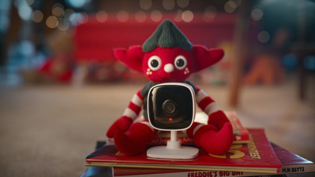 Vodafone is celebrating the power of connection in its new Christmas advert featuring a hero elf and a young girl's scheme to capture Santa on camera, here depicting a red toy elf behind a camera