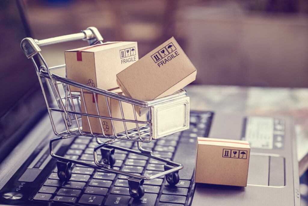 Mini shopping trolley on a laptop keyboard to represent the click and spend of e-commerce. Klarna has leveraged AI to increase the number of campaigns it puts out, all while cutting its sales and marketing spend by 11% in Q1 2024.